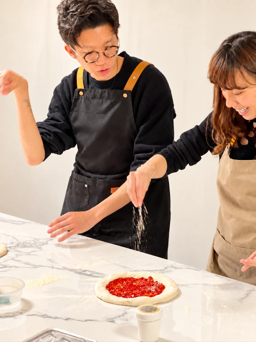 參加者一同為 Pizza 加上配料